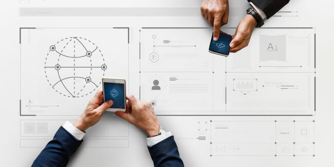 Two people using smartphones over a digital workflow interface on a table.