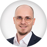 Webinar_Sprecher_Marcel Porträt von Marcel, einem Webinar-Sprecher mit Brille, Bart und Anzug.