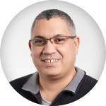 speedikon_Webinar_Sprecher_Emanuele Porträt von Emanuele, einem Webinar-Sprecher mit Brille und dunklem Pullover.